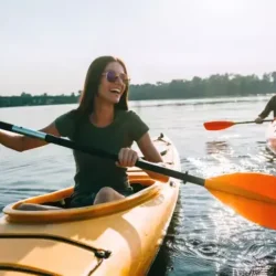 Kayak Single could be A person kayaking on calm waters with Dubai's iconic skyline in the background, surrounded by serene natural beauty