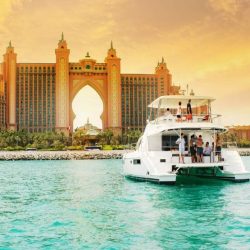 Yacht sailing through the calm waters with Dubai skyline in the background