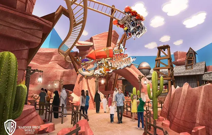 Visitors enjoying rides and attractions in the Cartoon Junction section of Warner Bros World Dubai, with colorful buildings and decorations in the background.