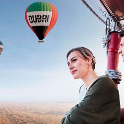 Hot air balloon flying over Dubai desert with sunrise view