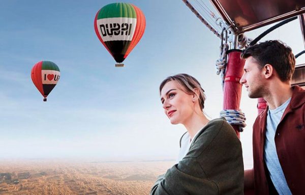 Hot air balloon flying over Dubai desert with sunrise view