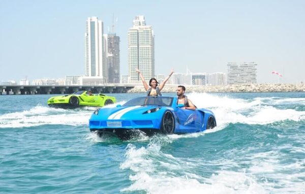 Alt text for the image of Jet Car Ride over the Gulf Ocean could be "A high-speed jet car flying over the calm blue waters of the Gulf Ocean, with a clear blue sky and sandy coastline in the background.